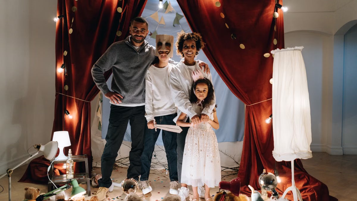 A joyful family enjoying imaginative play in a home theatre setting with costumes and creativity.